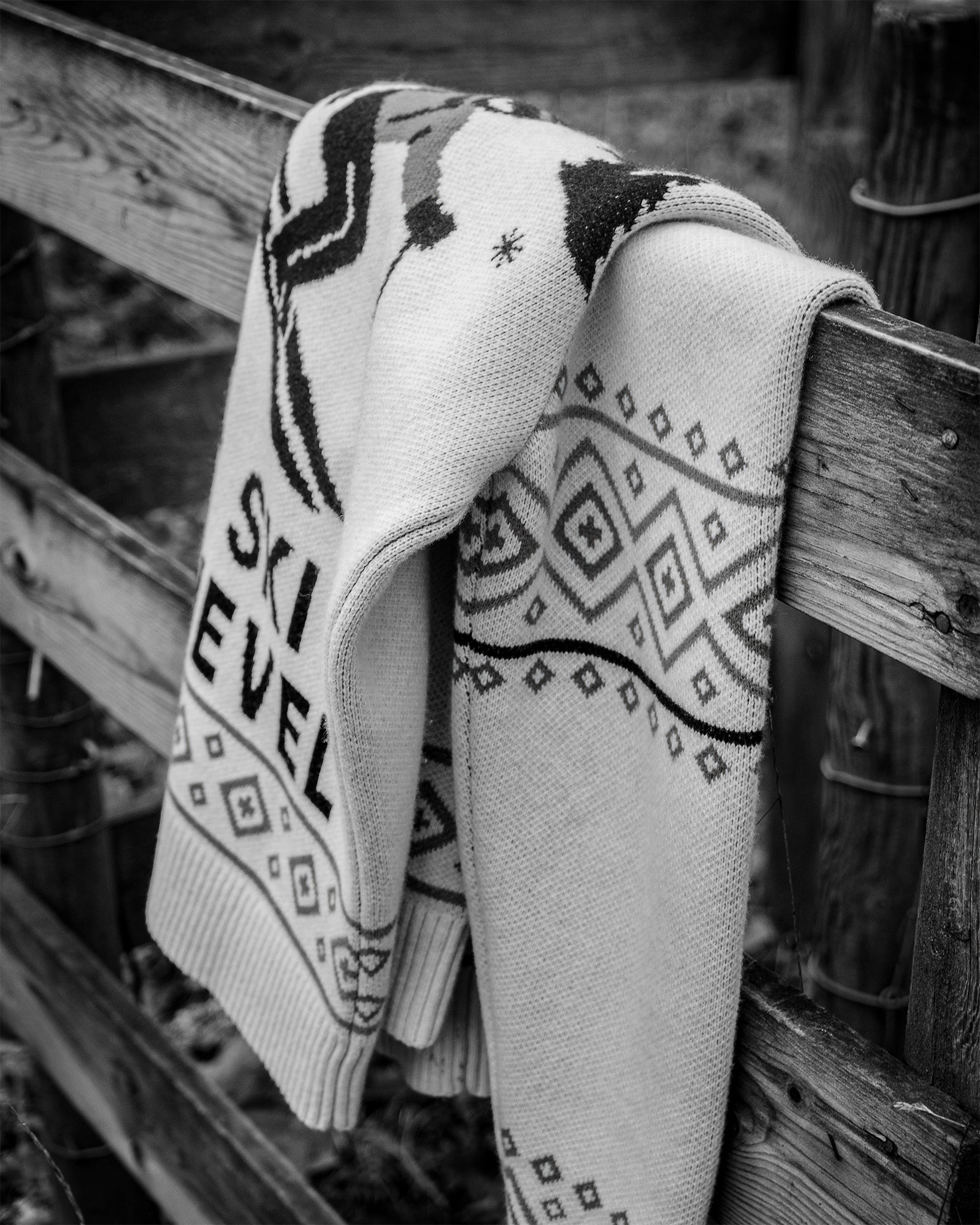 Patterned ski cover draped over a wooden railing