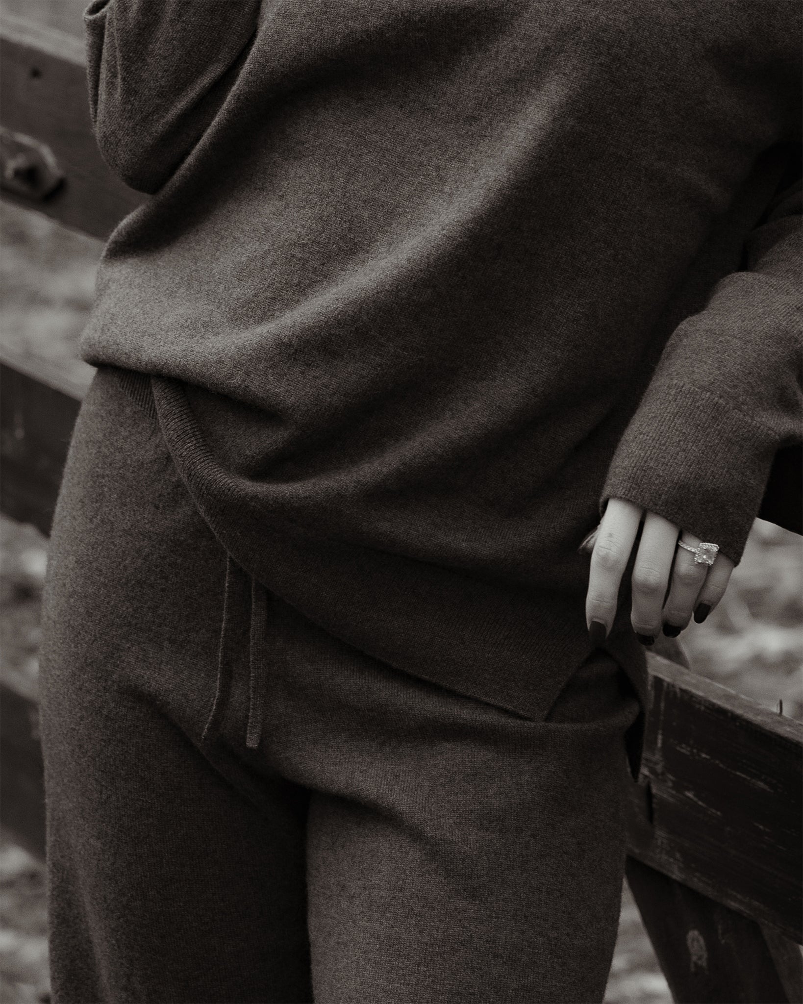 Person wearing a dark brown outfit with a blurred natural background